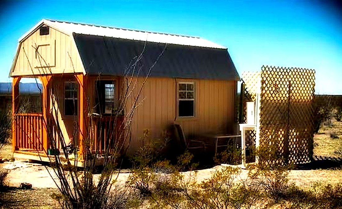 Angled view of the cabin porch with ocotillo branches in the foreground