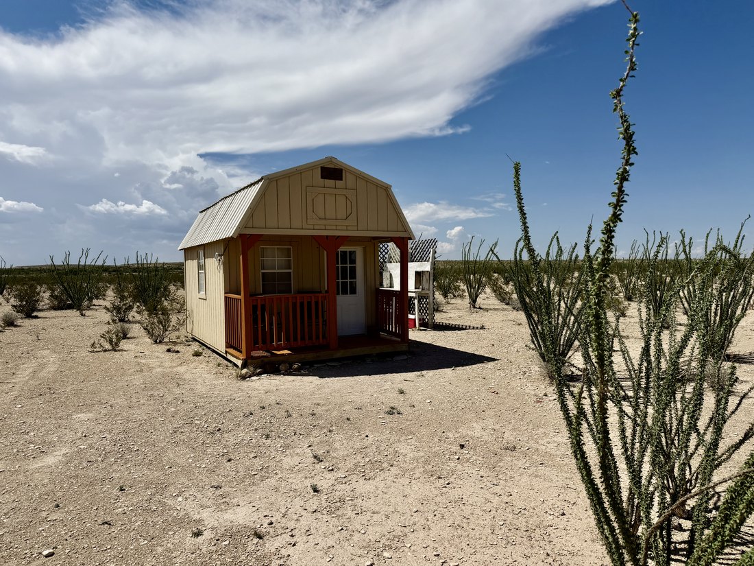 Side view of the cabin surrounded by open desert scrub