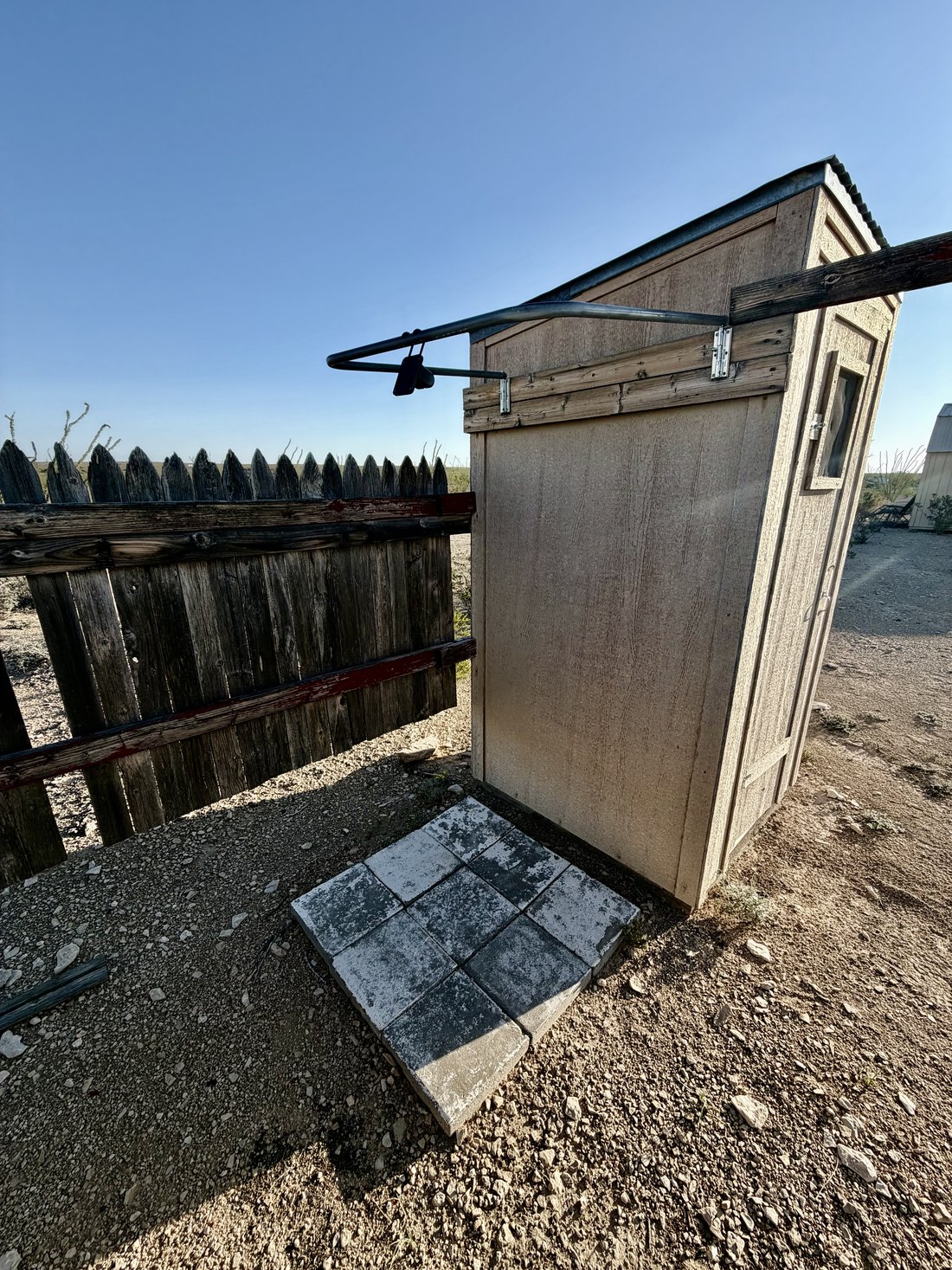 Small timber framed bath house structure behind the cabin