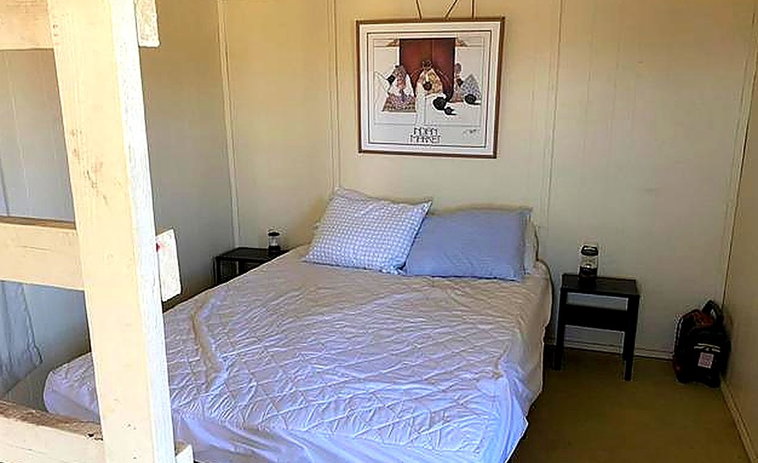 Interior bedroom with a made bunk bed against panelled walls