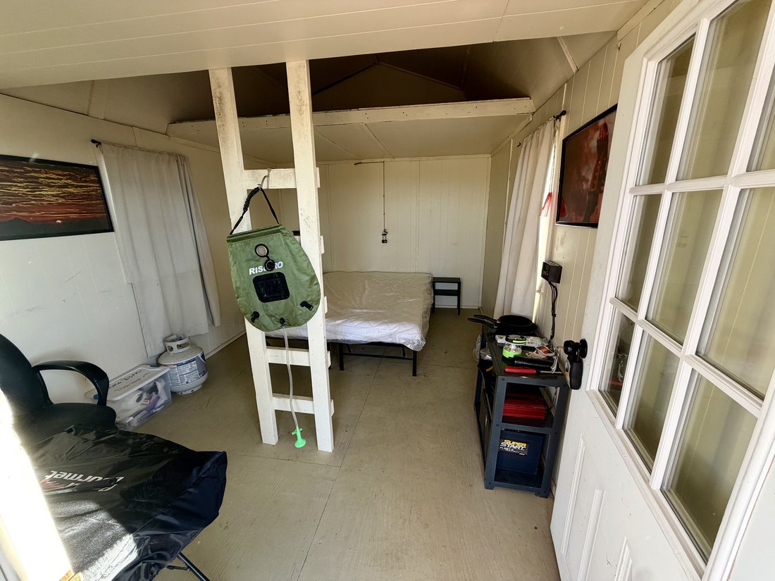 Wide interior view of the cabin showing the loft ladder, seating and the glazed front door